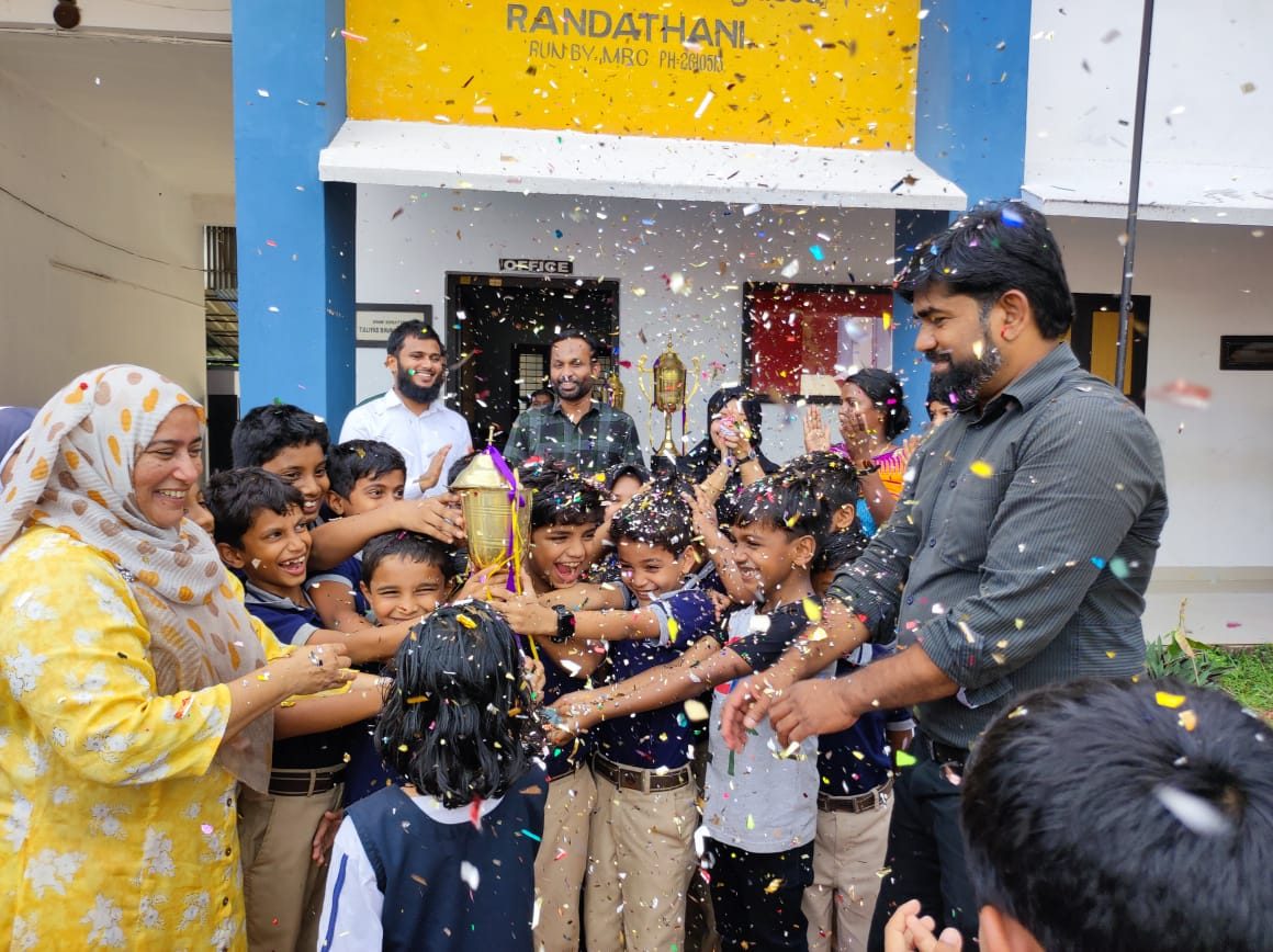 Children and teachers celebrating with confetti at the sports meet