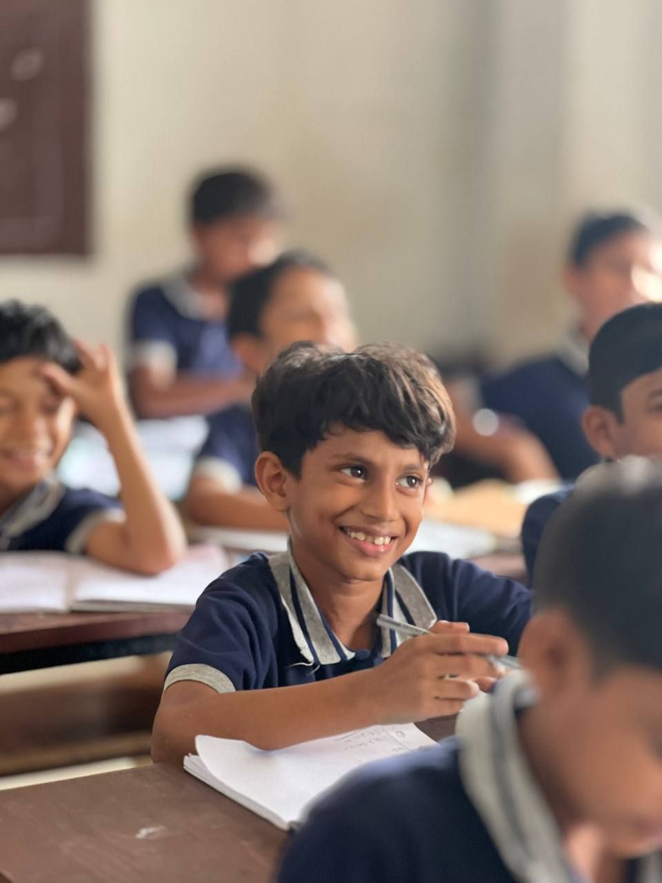 A smiling student writing in class