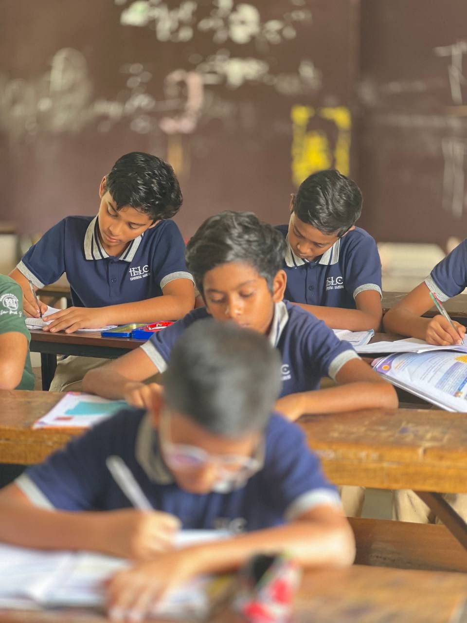 Students writing at wooden desks